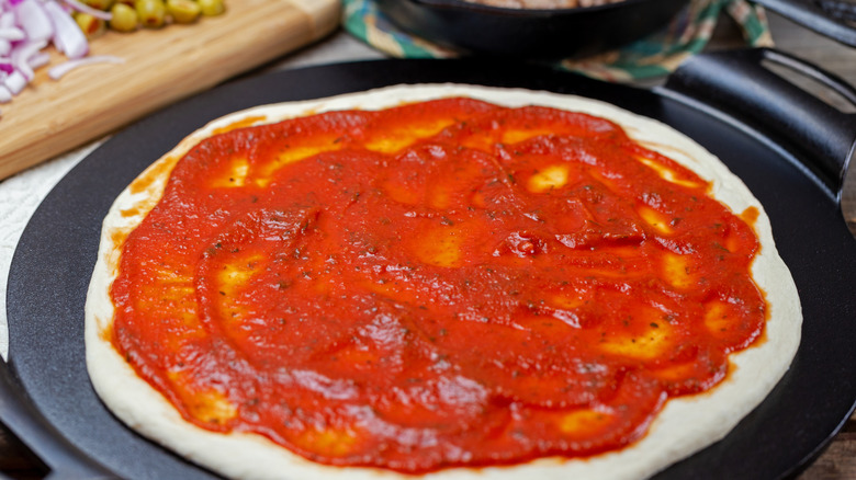 Red sauce on a pizza base