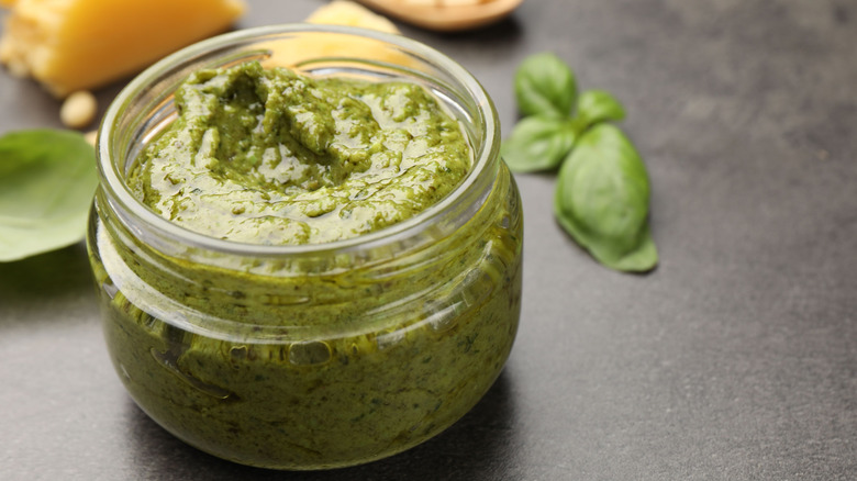 Homemade green pesto in clear jar