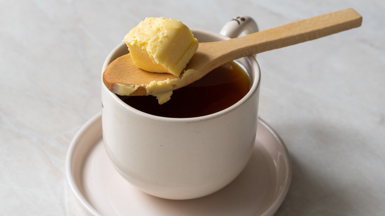 butter on wooden spoon on top of coffee