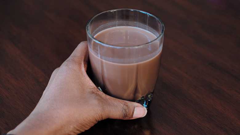 woman holding a glass of chocolate milk