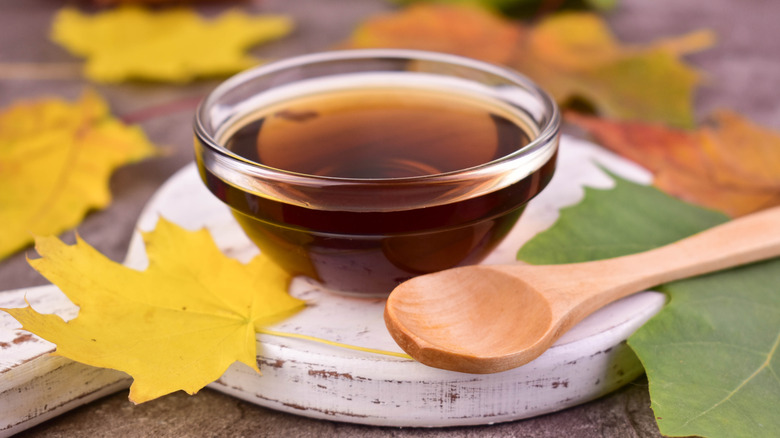 maple syrup in clear ramekin with wooden spoon