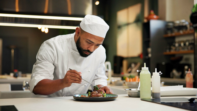 Chef plating food in restaurant kitchen