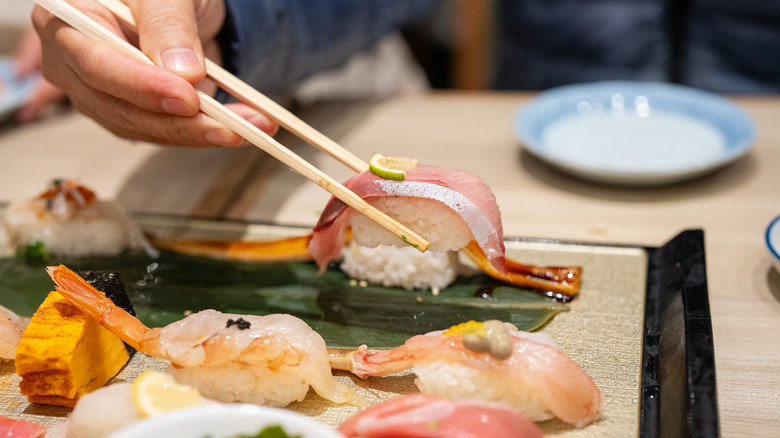 Chopsticks holding sushi