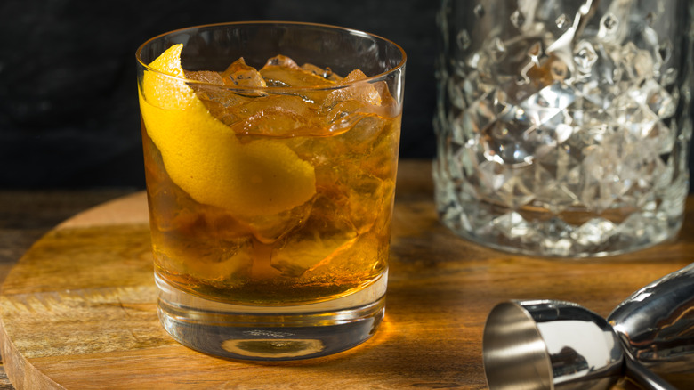 A mixed drink with a lemon wedge on a table