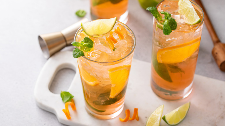 Sleepy Head cocktails on a stone cutting board with fresh mint and citrus