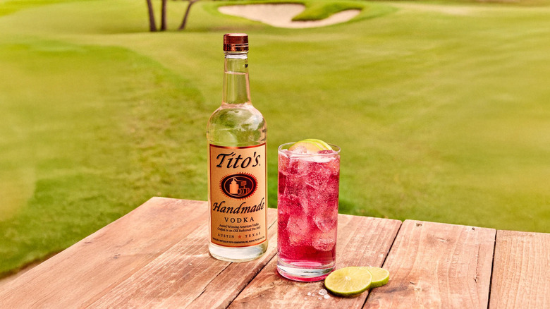 Transfusion cocktail next to a bottle of Tito's vodka