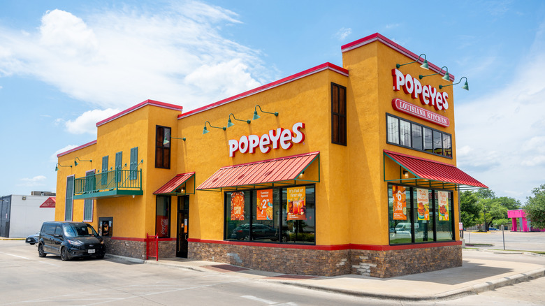Popeyes Louisiana Kitchen storefront with drive-thru on sunny day