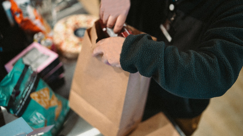 Close up on a person bagging groceries at checkout line