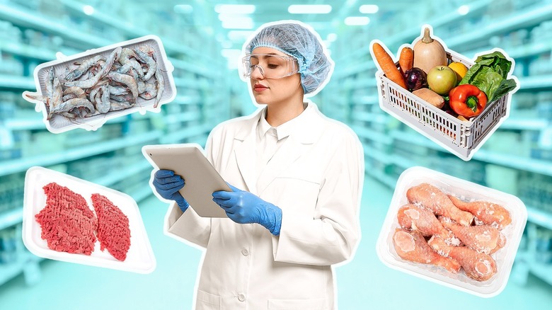 A woman in safety lab wear PPE surrounded by groceries such as meat and produce