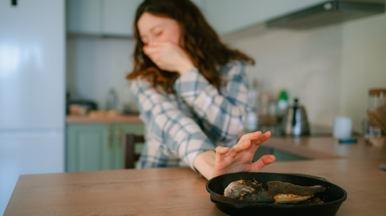 woman covering mouth and pushing food away