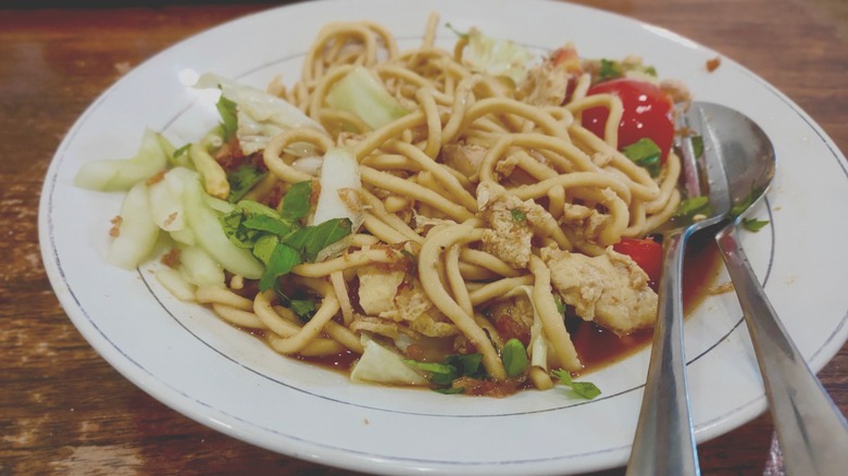 Longevity noodles with fork and spoon on a white plate