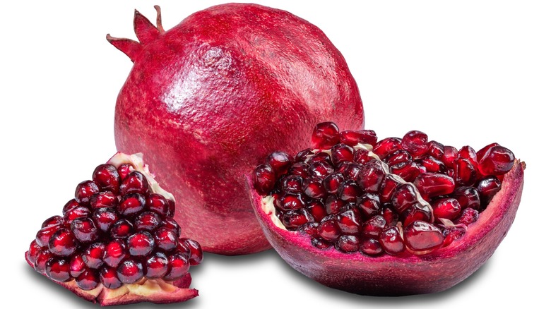 Red ripe pomegranate cut in half on white background