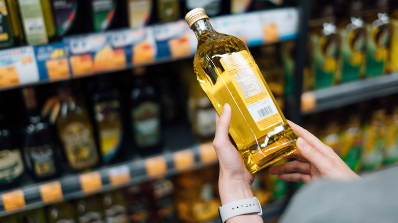 Person examining olive oil in store