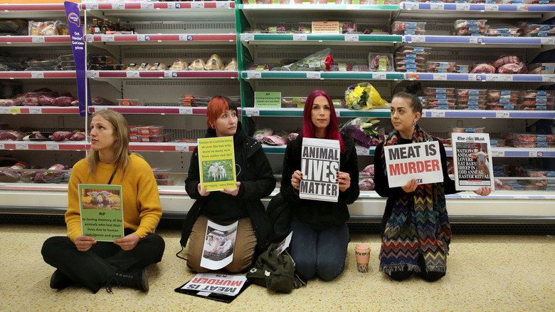 Protestors sitting in front of meat at grocery store