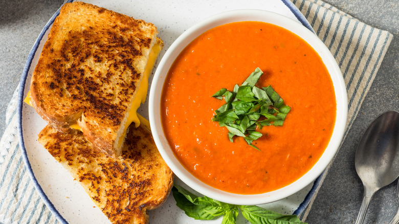 Tomato soup with shredded basil on top and grilled cheese sandwich