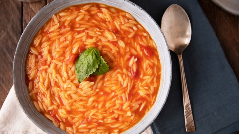 Orzo in tomato soup with spoon