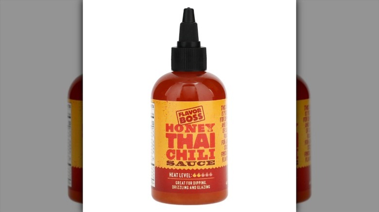 A squeeze bottle of Flavor Boss Honey Thai Chili Sauce on a white background.