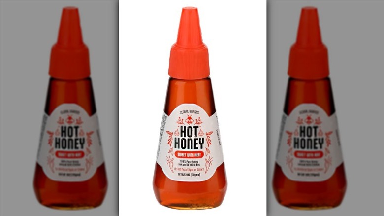 A squeeze bottle of Global Brands Hot Honey on a white background.
