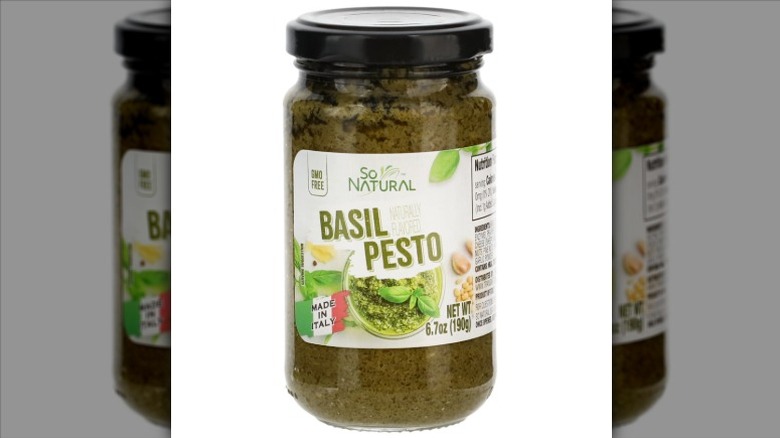 A jar of So Natural Basil Pesto on a white background.