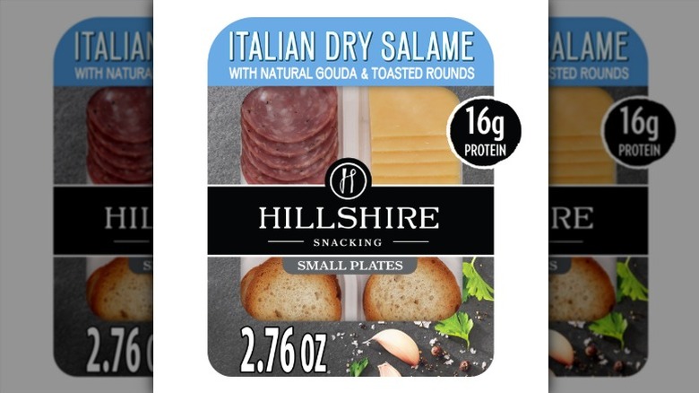 Hillshire Snacking Small Plates package with dry salami, gouda cheese, and crackers on a white background.