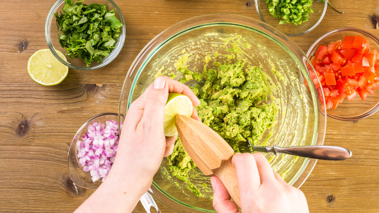 Squeezing lime while making homemade guacamole