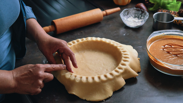 Woman's hands pressing pie crust into pie plate