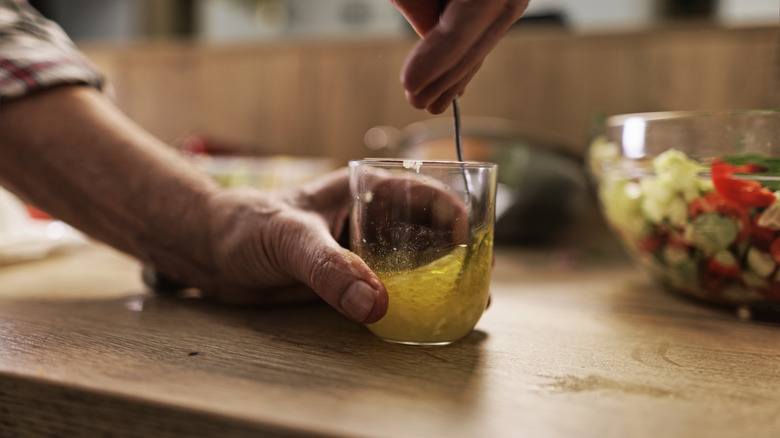Hands stirring salad dressing