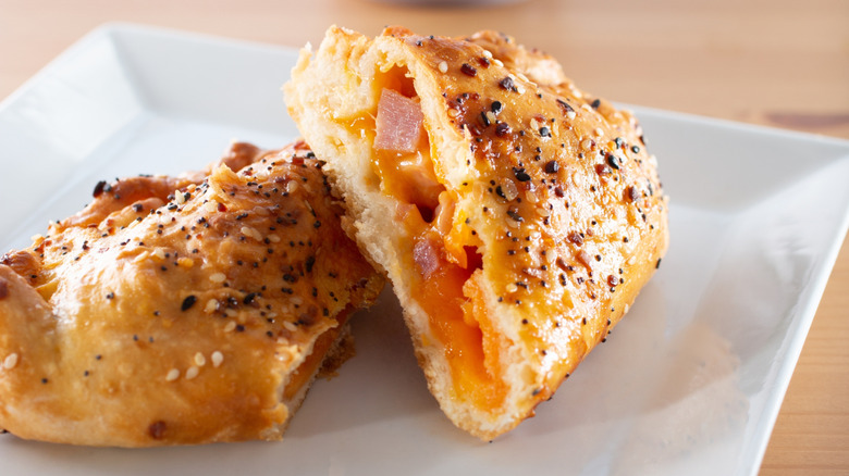 Ham and cheese hot pocket-style sandwich on white plate
