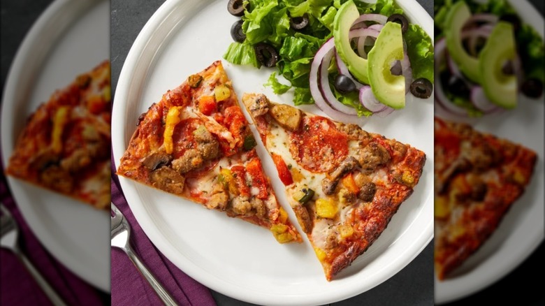 Two slices of pizza on a plate with salad