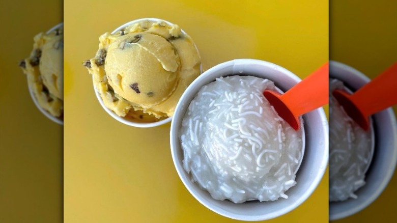 Saffron Pistachio and Faloodeh Persian ice cream scoops from Saffron & Rose in separate paper cups on a yellow background
