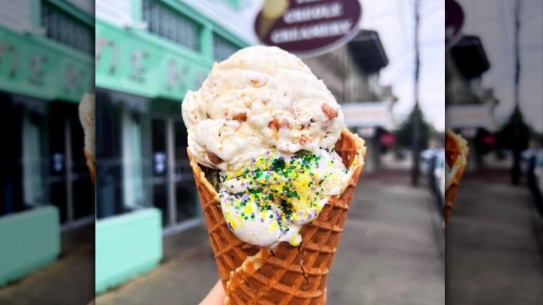 chicken and biscuits and king cake ice cream in a waffle cone from The Creole Creamery held in front of the storefront