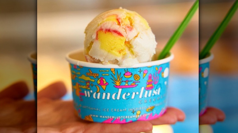 blue paper cup with scoops of white ice cream with yellow and red swirls from Wanderlust Creamery