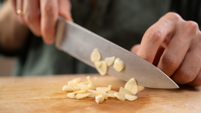 Hands cutting garlic cloves