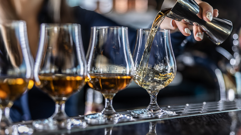 Glasses of whiskey being poured