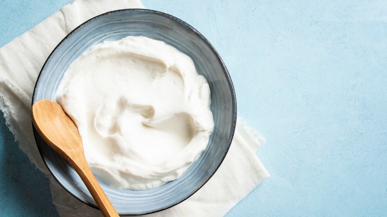 Bowl of sour cream with wooden spoon