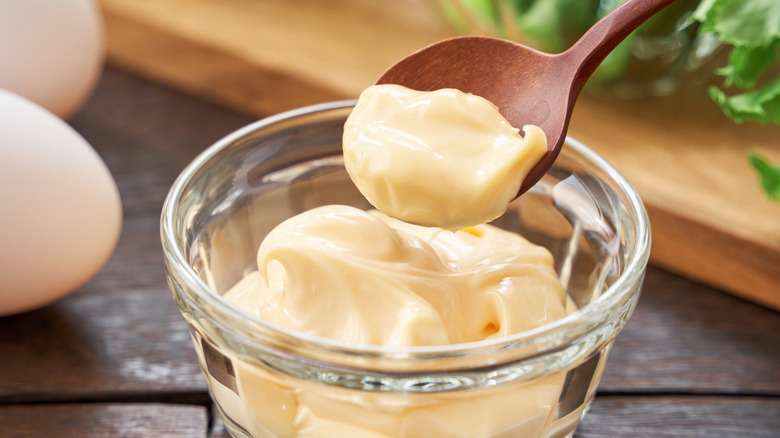 Spoon lifting mayo from bowl of mayo
