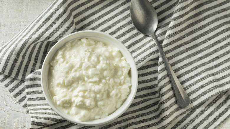 Bowl of cottage cheese with spoon and napkin