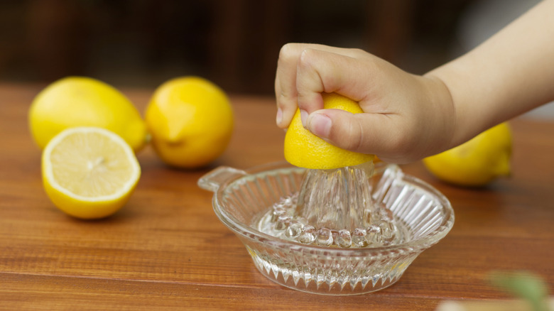 Child's hand juicing lemon
