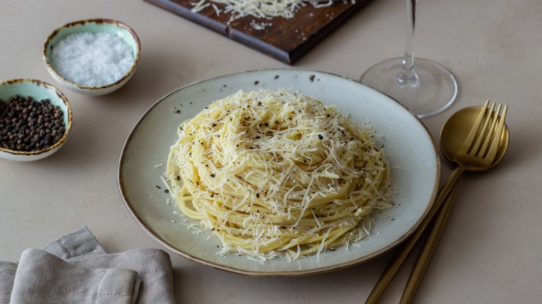 A plate of cacio e pepe spaghetti with black pepper and cheese