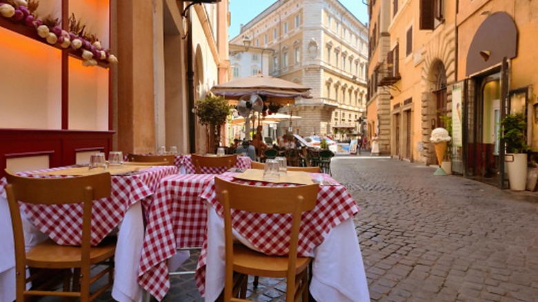 Outdoor tables with red and white checked tablecloths at a traditional Italian restaurant