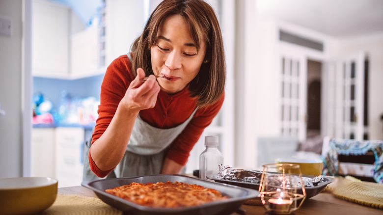 Woman tasting plate of food