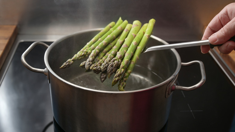Lowering asparagus into a pot of water
