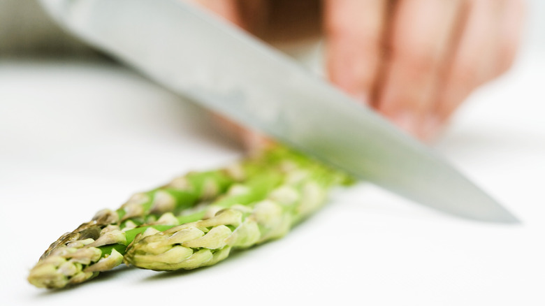 Person cutting asparagus with knife