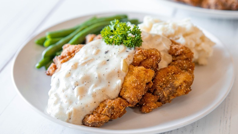 Chicken fried steak with gravy, mashed potatoes, and green beans