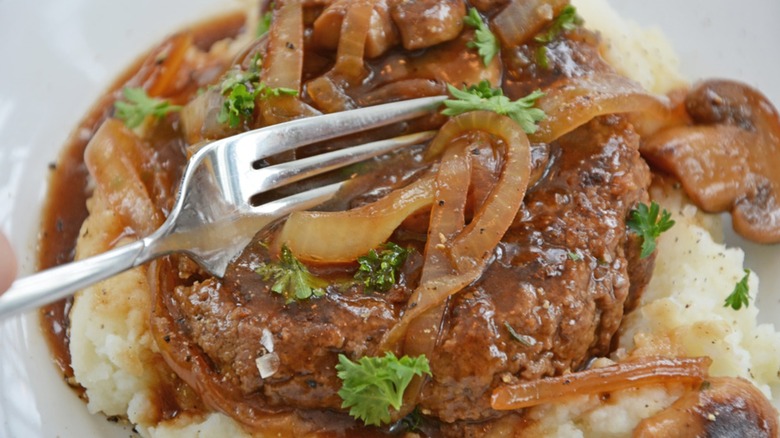 Fork cutting into salisbury steak