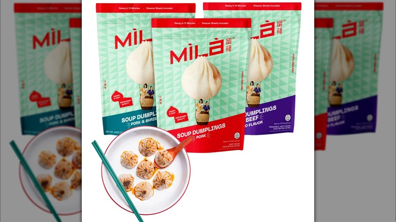 Three bags of assorted Mila soup dumplings next to a plate with cooked dumplings on it.