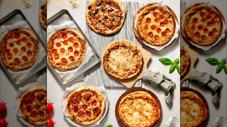 Six assorted Pizzeria DeLuna pies on plates