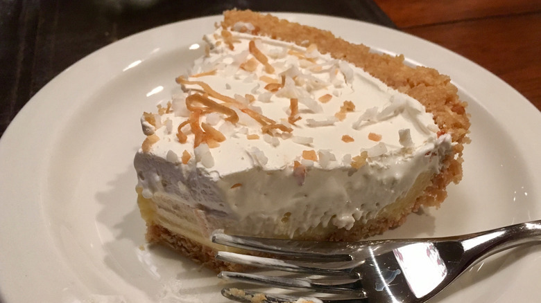 Half-eaten coconut cream pie with fork