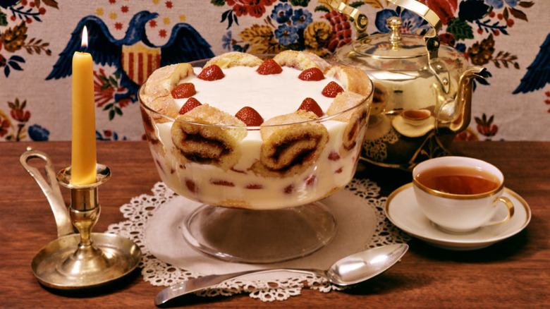Old-fashioned trifle with candle and tea cup