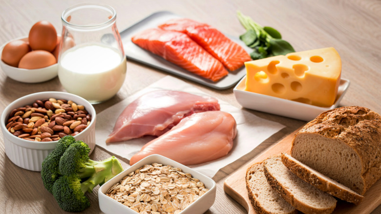 Variety of whole foods including salmon, nuts, oats, bread, chicken, cheese, and eggs